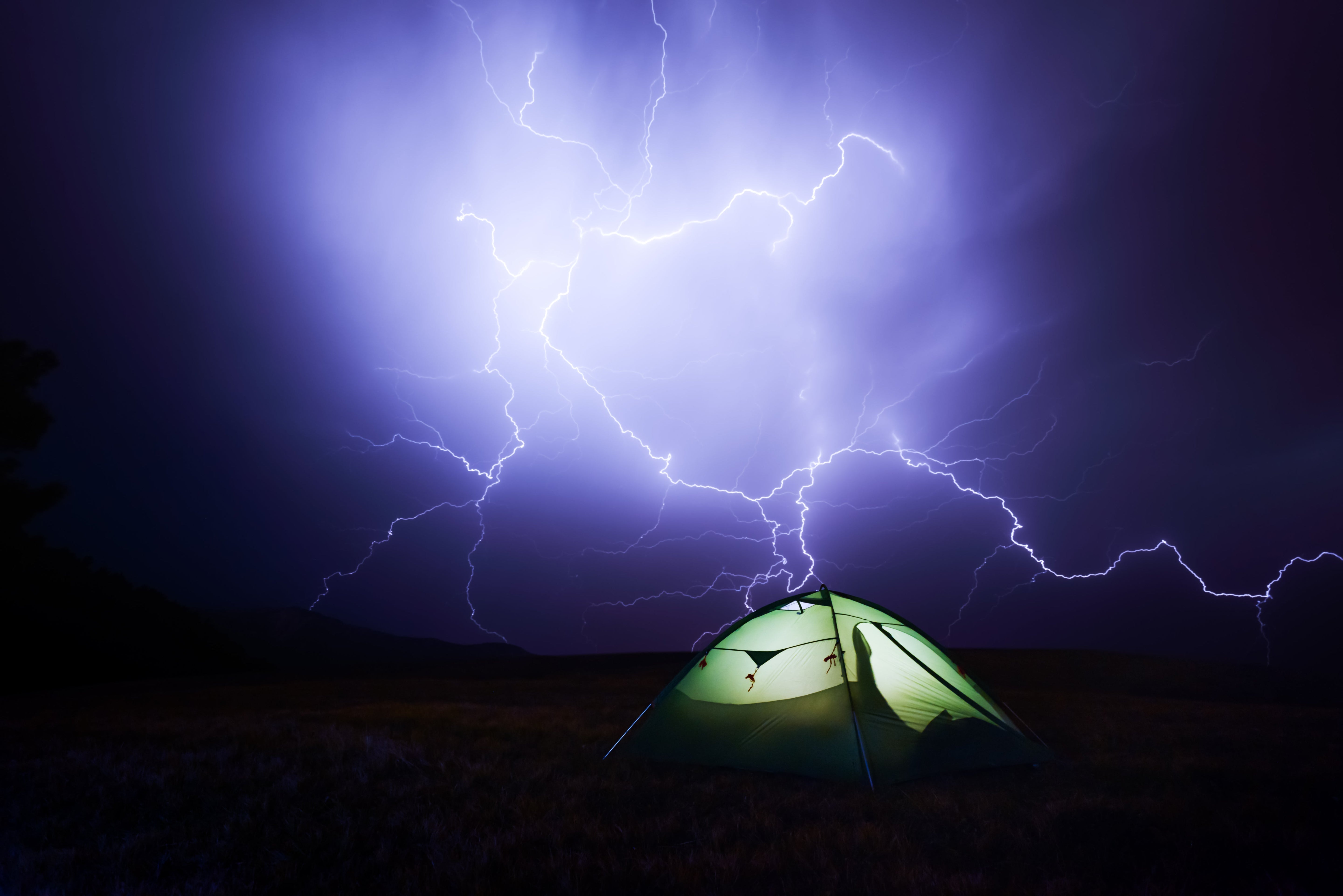 Gewitter beim Camping? Keine Panik! Ein Heller blitz schlägt in ein beleuchtetes Zelt ein