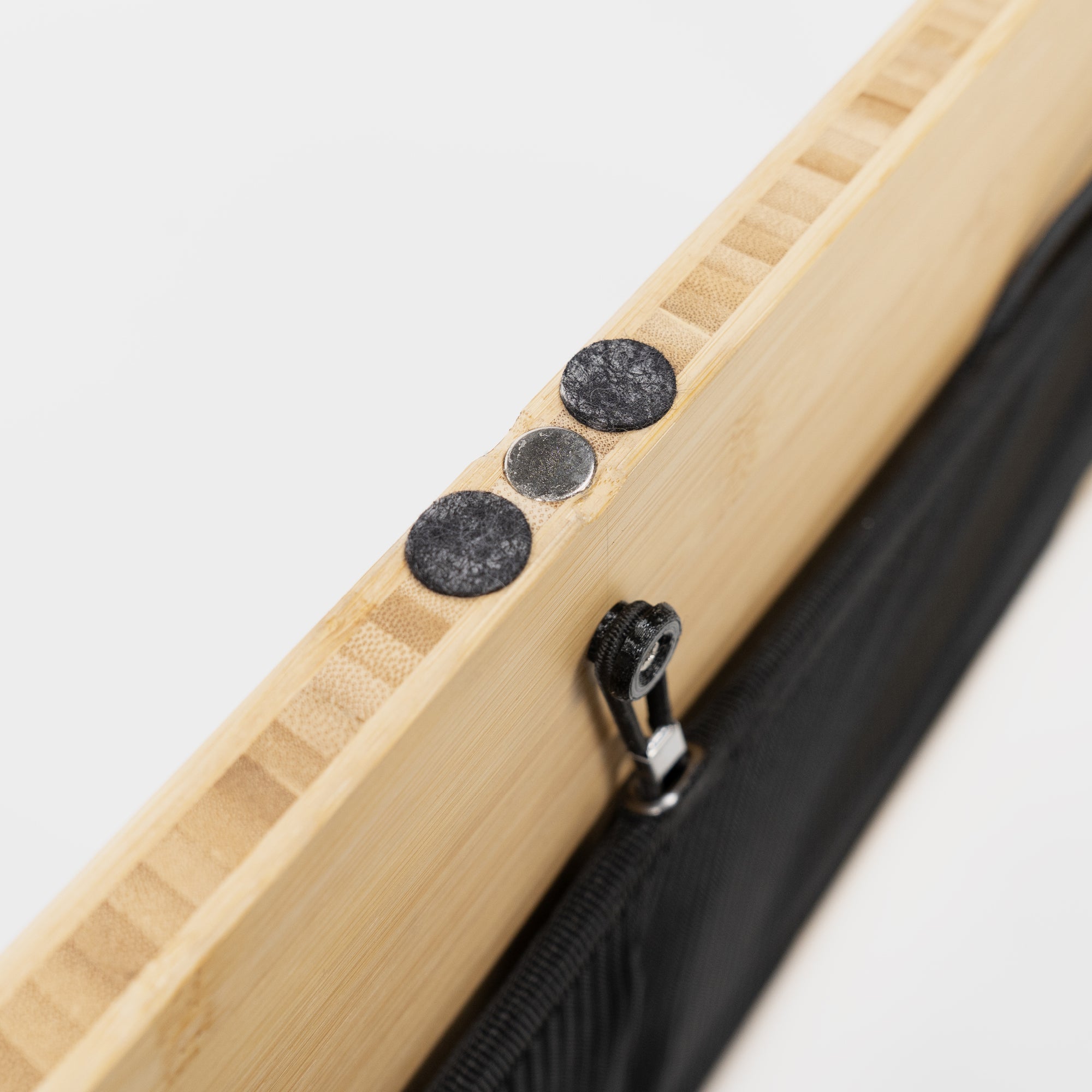 Oberfläche eines Holzbretts aus Bambus mit Klebepunkten und einem Zipper an der Seite.